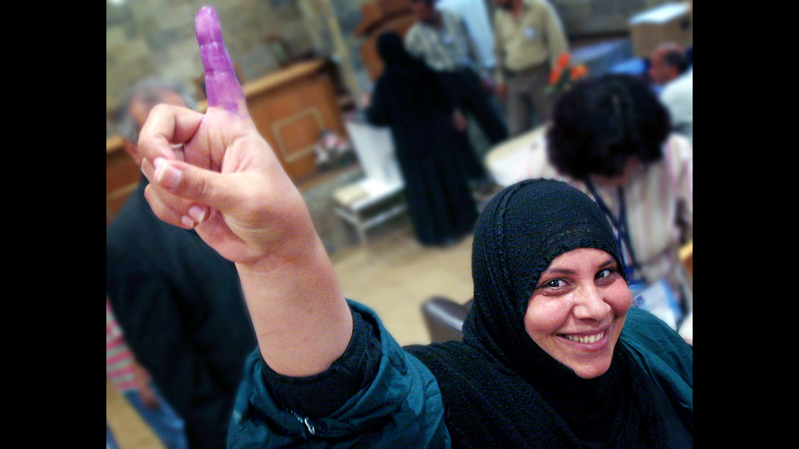 An employee at Yarmouk Hospital raises her inked finger after voting in the constitutional referendum in Baghdad October 13, 2005. An election official announced that voting on the draft constitution of Iraq would begin today at detention centers and hospitals and would last for a total of three days, with the last being the Referendum Day, October 15, 2005. REUTERS/Thaier Al-Sudani PP05100181 - RTR19CRI