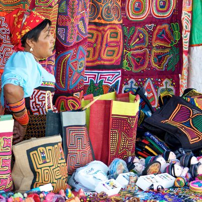 PANAMA CITY, PANAMA - JANUARY 18, 2014: A Kuna woman selling molas in an open air market in Panama City. The Kuna people, also known as Guna, are indigenous people of Panama and Colombia. ; Shutterstock ID 180144593; PO: BB: Country Photos for Website