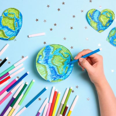 Female,Hand,Draws,Planet,Earth,With,Multicolored,Felt-tip,Pens,On