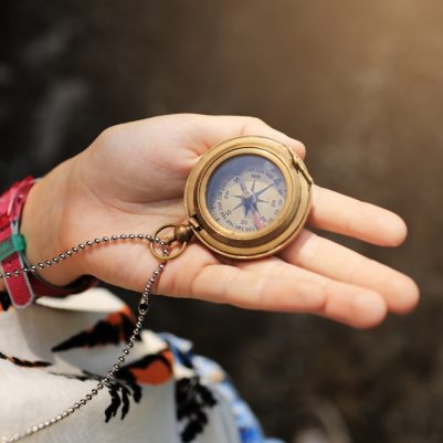 Girl,Holding,Compass,In,The,Hand.,Child,Exploring,Nature,In